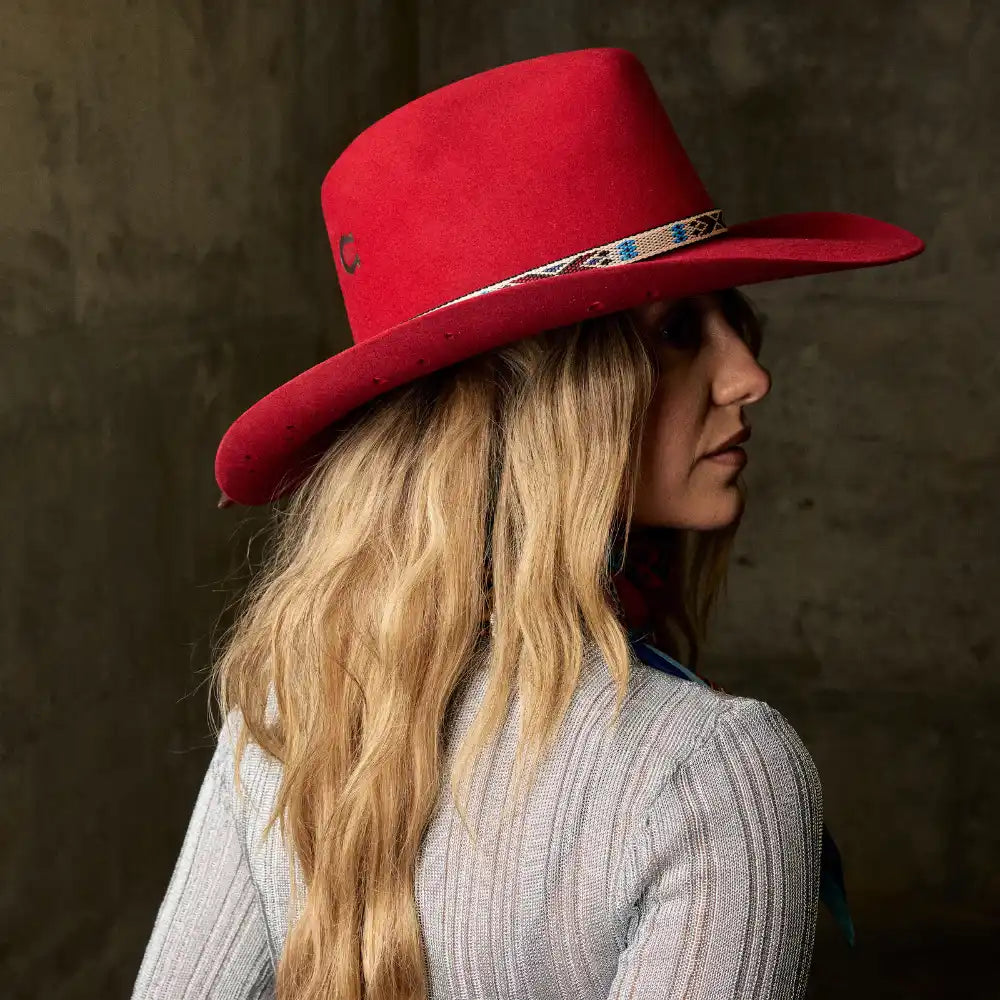 Blonde woman in a red cowboy hat and light gray sweater
