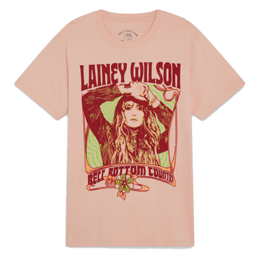 Pink t-shirt featuring a retro-style graphic design of a woman with long hair and the name ’Lainey Wilson’ in red text.
