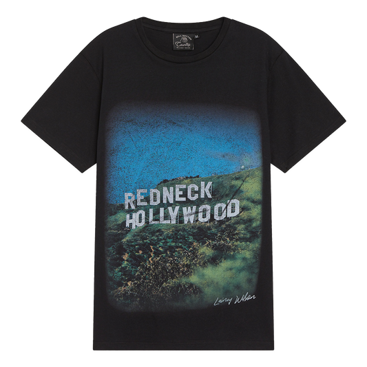 Black t-shirt featuring a graphic design of ’Redneck Hollywood’ text over a hillside landscape.