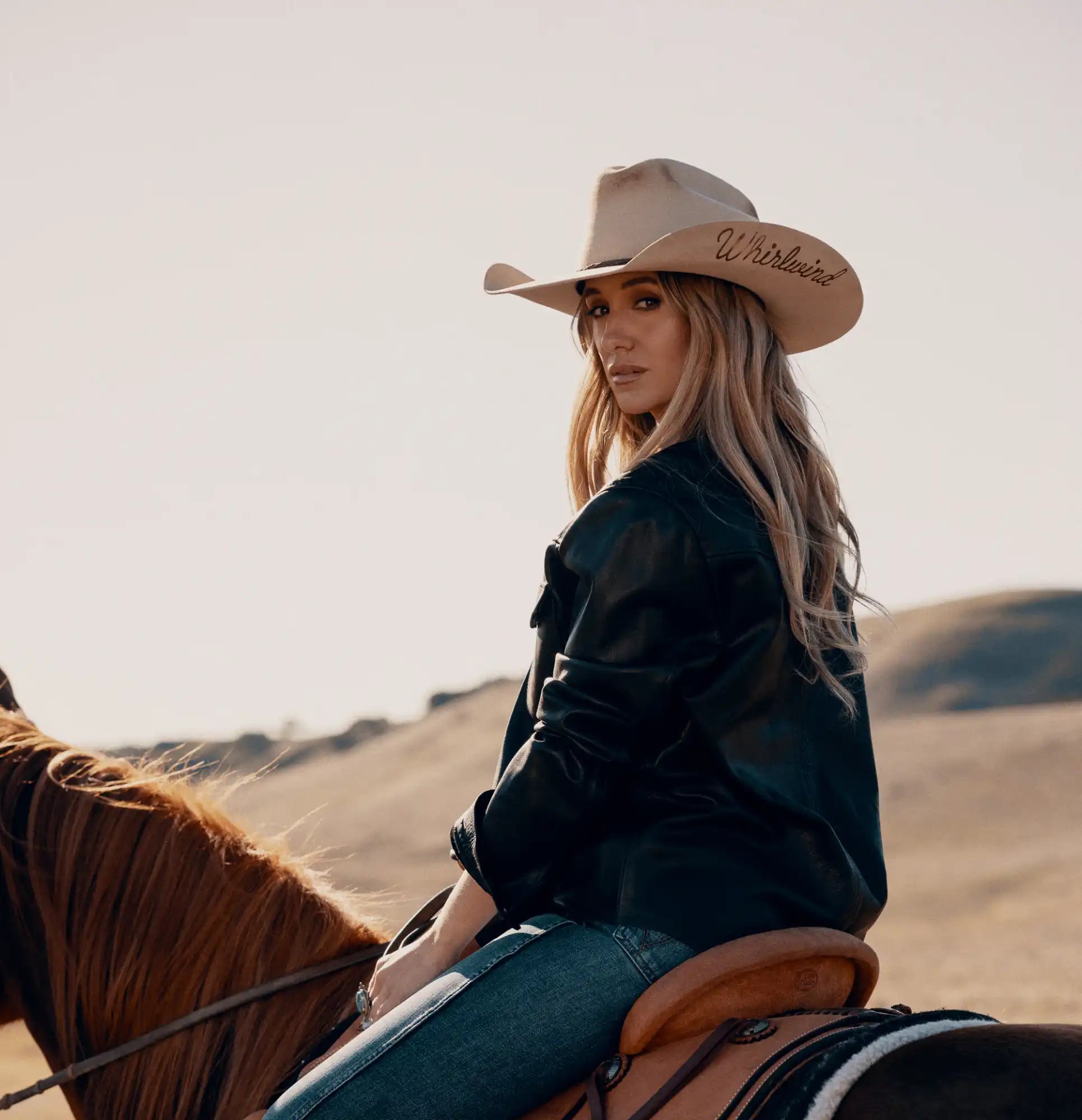 Woman on horseback wearing a cowboy hat