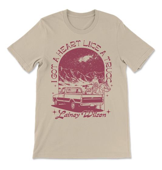 Beige t-shirt with a red vintage-style graphic design featuring a truck, mountains, and text.