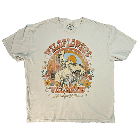 Beige t-shirt with a vintage-style cowboy and horse graphic design featuring ’Wildflowers and Wild Horses’ text.